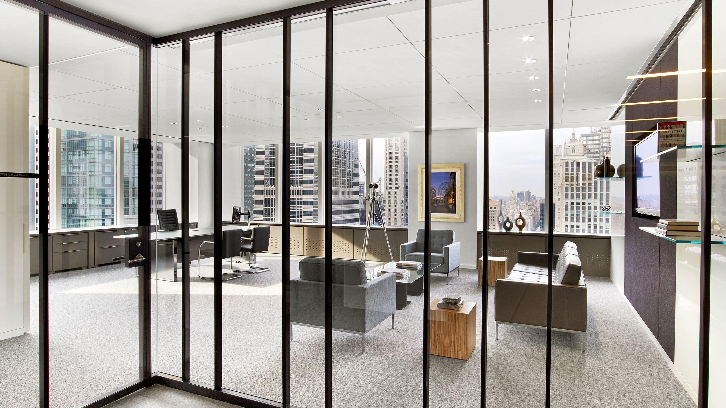 Modern office interior featuring Ultralight demountable glass partitions with a bespoke dark blue anodized aluminum finish.